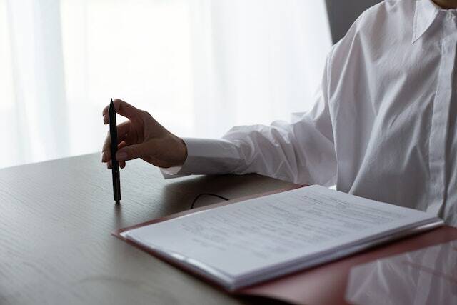 person holding pen before signing lease contract